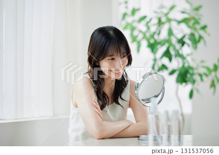 笑顔で鏡を覗き込む若い女性 131537056