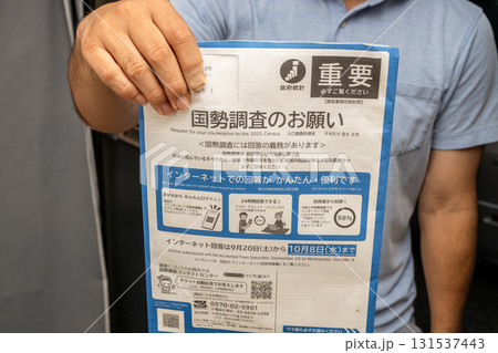 国勢調査のお知らせを届けている男性の素材写真 131537443