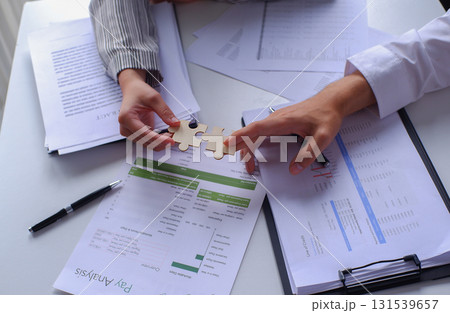 Closeup hands of two business people connecting jigsaw puzzle. Business solutions, success and strategy concept. Closeup hands of two business people connecting jigsaw puzzle. Business solutions, success and strategy concept. 131539657