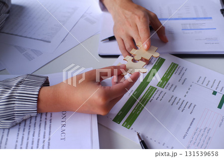 Closeup hands of two business people connecting jigsaw puzzle. Business solutions, success and strategy concept. Closeup hands of two business people connecting jigsaw puzzle. Business solutions, success and strategy concept. 131539658