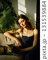 A woman is sitting on a couch with a cat on her lap 131539884