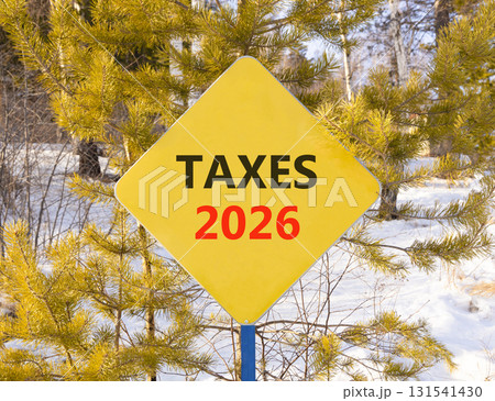 Taxes 2026 new year symbol. Concept words Taxes 2026 on beautiful yellow road sign. Beautiful winter forest background. Business and taxes 2026 new year concept. Copy space. Taxes 2026 new year symbol. Concept words Taxes 2026 on beautiful yellow road sign. Beautiful winter forest background. Business and taxes 2026 new year concept. Copy space. 131541430