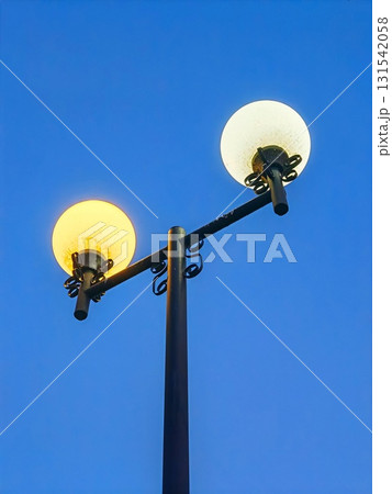 Park lamp in beautiful evening sky over a city during late winter. street lamp in the evening on the background of the sky. Round, glowing balls. 131542058