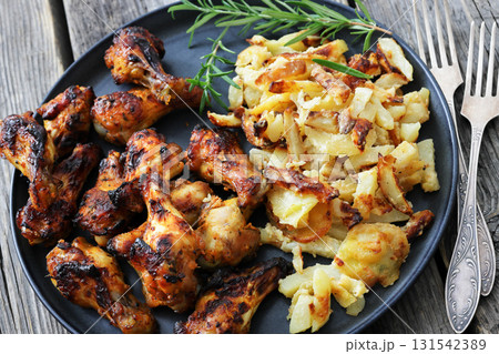 bbq chicken wings with fried potatoes on plate bbq chicken wings with fried potatoes on plate 131542389