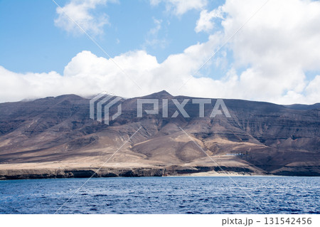 波の立つ広々とした海と遠くに見える茶色のはげ山 カナリア諸島のフエルテベンテュラ島の海上にて 波の立つ広々とした海と遠くに見える茶色のはげ山 カナリア諸島のフエルテベンテュラ島の海上にて 131542456