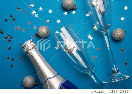 Champagne Bottle and Flutes with Silver Ornaments for New Year Celebration on Blue Background 131542557