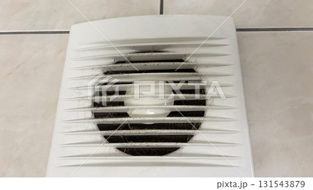 Close-up of an electric range hood clogged with dust and cobwebs, dirty exhaust fan in the bathroom with accumulated dirt, concept of pollution, poor ventilation and need of cleaning 131543879