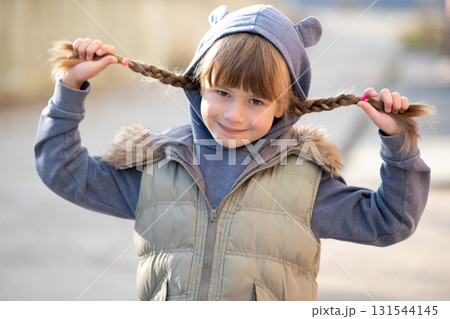 Portrait of happy child girl with hair braids in warm clothes in autumn outdoors. Portrait of happy child girl with hair braids in warm clothes in autumn outdoors. 131544145