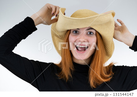 Portrait of funny redhead woman in bag yellow straw hat. Portrait of funny redhead woman in bag yellow straw hat. 131544147