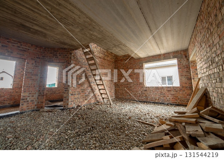 Interior of unfinished brick house with concrete floor and bare walls ready for plastering under construction. Real estate development 131544219