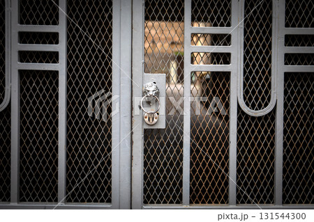 Close-Up of Locked Metal Gate with Decorative Pattern and Rust Close-Up of Locked Metal Gate with Decorative Pattern and Rust 131544300