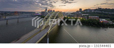Highway traffic in Cincinnati, Ohio on Daniel Carter Beard Bridge with brightly illuminated high skyscraper buildings in downtown district. American city with business financial district at night 131544401