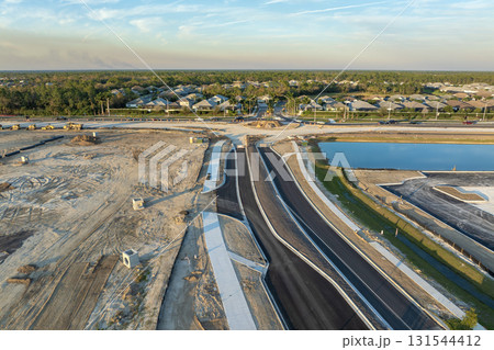 Highway construction in North Port, Florida. Development of American road with moving traffic cars. City transportation improvement Highway construction in North Port, Florida. Development of American road with moving traffic cars. City transportation improvement 131544412