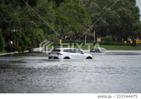 Flooded Florida street with stuck cars after hurricane Debby rainfall surrounded with water. Consequences of natural disaster Flooded Florida street with stuck cars after hurricane Debby rainfall surrounded with water. Consequences of natural disaster 131544475