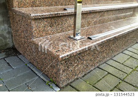 Detail of a house facade. New granite stairs with metal railings. Detail of a house facade. New granite stairs with metal railings. 131544523