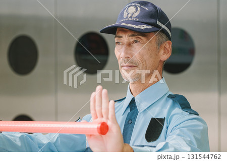 交通誘導をする警備会社のガードマン 131544762