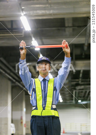 交通誘導をする警備会社のガードマン 131545009