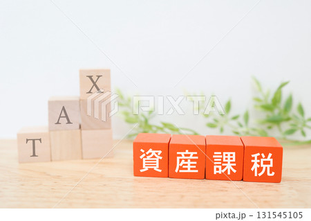 資産課税を示す赤ブロック。背後の階段上に積み上げた積み木にTAXの文字。 131545105