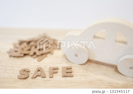 木製のおもちゃの車とSAFEの文字。交通安全や安全運転のイメージ。 131545117