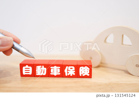 木製の車と自動車保険の文字ブロック。コピースペースあり。 131545124