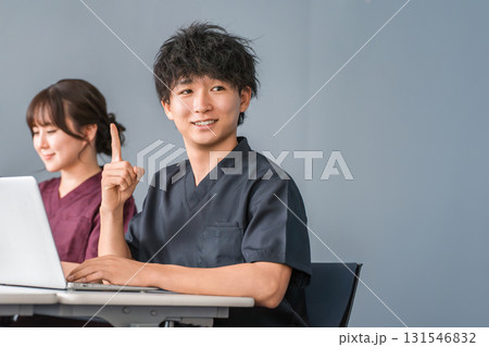 パソコンの前にいるスクラブ姿の若いアジア人男性（医療従事者,看護師,医師） 131546832