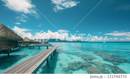 Wooden pier linking thatched overwater bungalows reaching into turquoise waters, tropical islands rising against blue sky backdrop 131548733