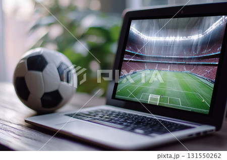Online sports betting with laptop showing soccer stadium and ball 131550262
