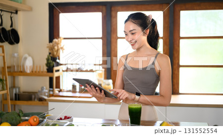Young woman using tablet with recipe online in the kitchen 131552554
