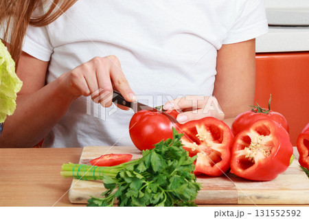 woman cutting tomatoes on kitchen woman cutting tomatoes on kitchen 131552592