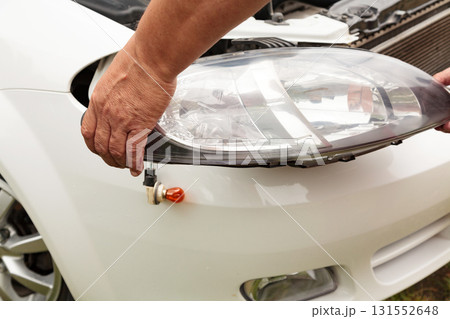 Head lights repair. Mechanic holding a new spare part 131552648