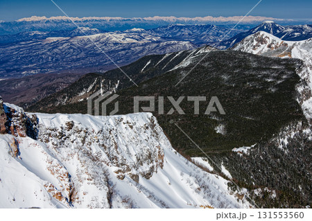 冬の八ヶ岳連峰・硫黄岳山頂から見る天狗岳・蓼科山と北アルプスの山並み 131553560