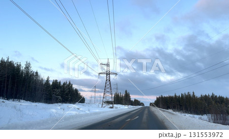 long the winter road, the wires of the high-voltage transmission line extend. long the winter road, the wires of the high-voltage transmission line extend. 131553972