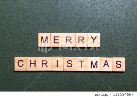 Merry Christmas text made of wooden letter blocks on green background 131554667