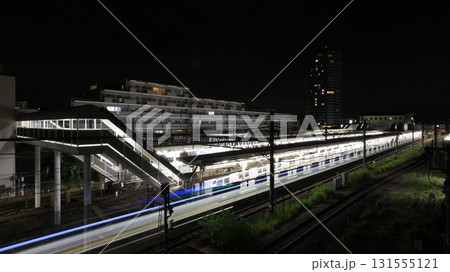 東急田園都市線の長津田駅の夜景、駅を出る電車の光跡 131555121
