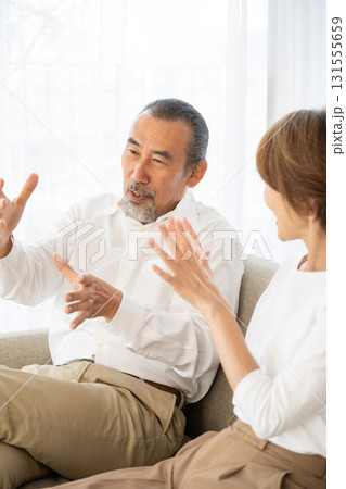 ソファで会話をするシニア夫婦 ソファで会話をするシニア夫婦 131555659