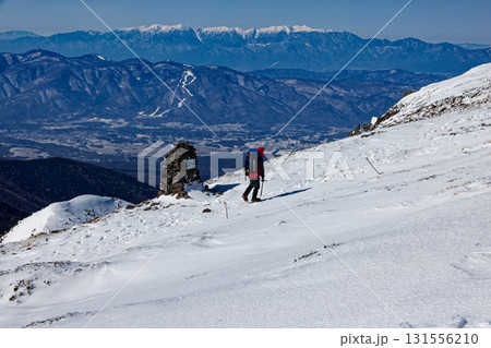 冬の八ヶ岳連峰・硫黄岳山頂を行く登山者と中央アルプス 131556210