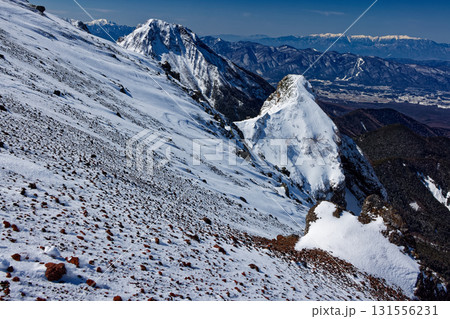 八ヶ岳連峰・横岳稜線から見る冬の大同心・阿弥陀岳と中央アルプスの山並み 131556231