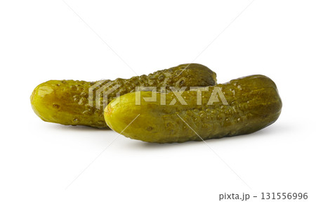 Two whole pickled gherkins resting on white background 131556996