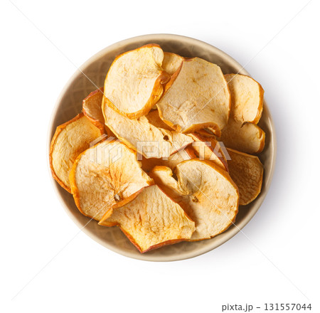 Dried apple chips in bowl on white background 131557044