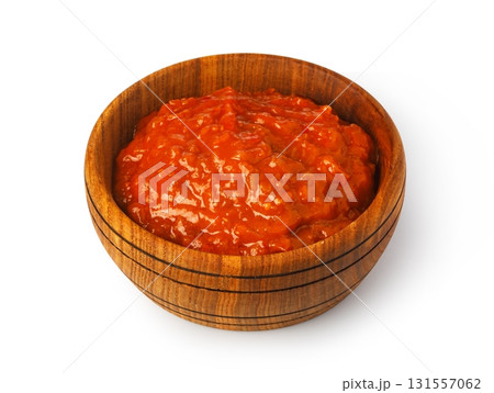 Red pepper sauce in wooden bowl on white background Red pepper sauce in wooden bowl on white background 131557062