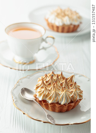Meringue lemon tart on a white wooden table. Meringue lemon tart on a white wooden table. 131557487