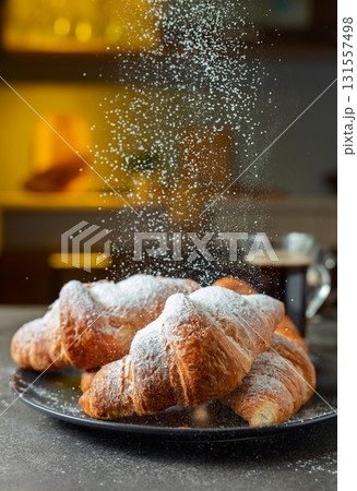 Croissants sprinkled with sugar powder. 131557498