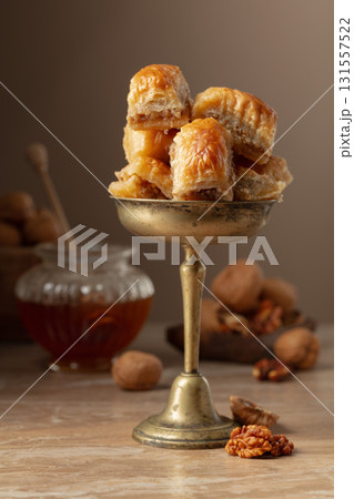 Baklava with walnuts and honey on a beige background. 131557522