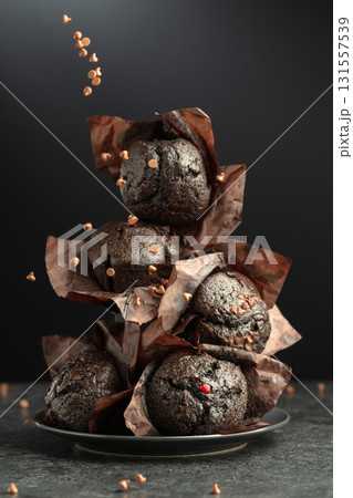 Dark chocolate muffins on a black background. 131557539