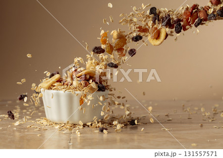 Muesli in motion on a beige background. Muesli in motion on a beige background. 131557571