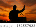 夕焼けの中で手を挙げる人のシルエット 131557922