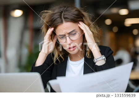 Businesswoman worried while reading risky report 131559639