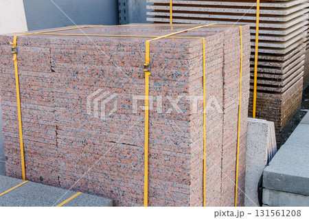 Pallets with stacked gray paving slabs selective focus Stack of paving slabs in warehouse road repair or finished tile sale space for text. High quality photo Pallets with stacked gray paving slabs selective focus Stack of paving slabs in warehouse road repair or finished tile sale space for text. High quality photo 131561208