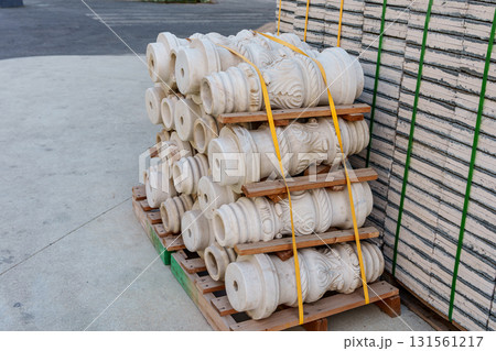 Pallets with stacked gray paving slabs selective focus Stack of paving slabs in warehouse road repair or finished tile sale space for text. High quality photo 131561217