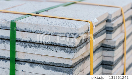 Pallets with stacked gray paving slabs selective focus Stack of paving slabs in warehouse road repair or finished tile sale space for text. High quality photo Pallets with stacked gray paving slabs selective focus Stack of paving slabs in warehouse road repair or finished tile sale space for text. High quality photo 131561241